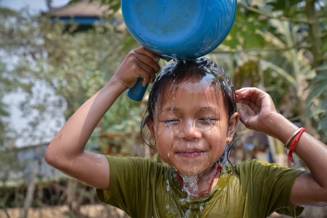 Mara, 5, is having her daily shower after school, in Bateay, Cambodia.