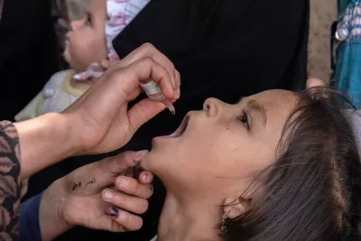 Bahareh, a volunteer vaccinator in Herat Province, vaccinates a child against polio outside her home. Just two drops of the oral polio vaccine, provided over four doses, can immunize a child against polio for life. 