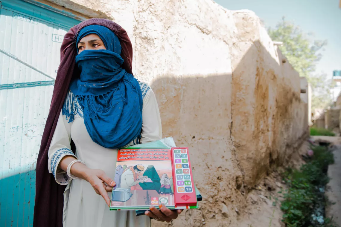 A female social mobilizer in Kandahar, Afghanistan, holds an audio book used to explain the importance of polio vaccinations