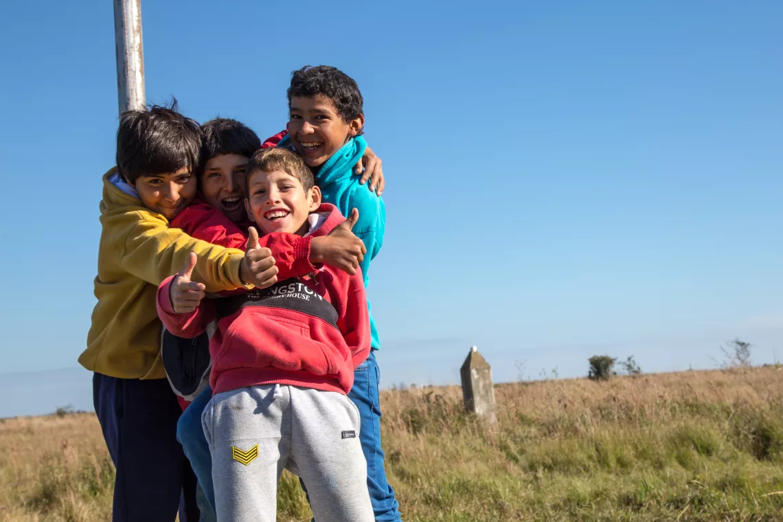 Un grupo de niños abrazados sonríe a cámara