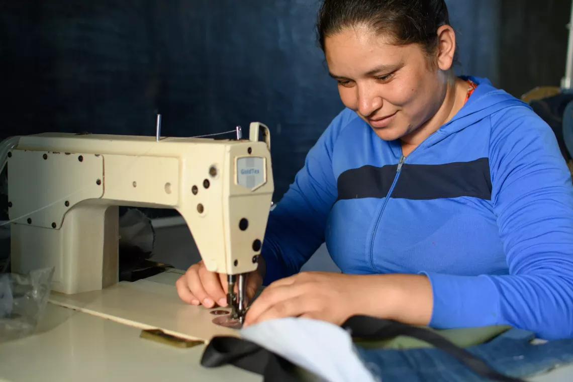 Una mujer cose una mochila en el taller de costura