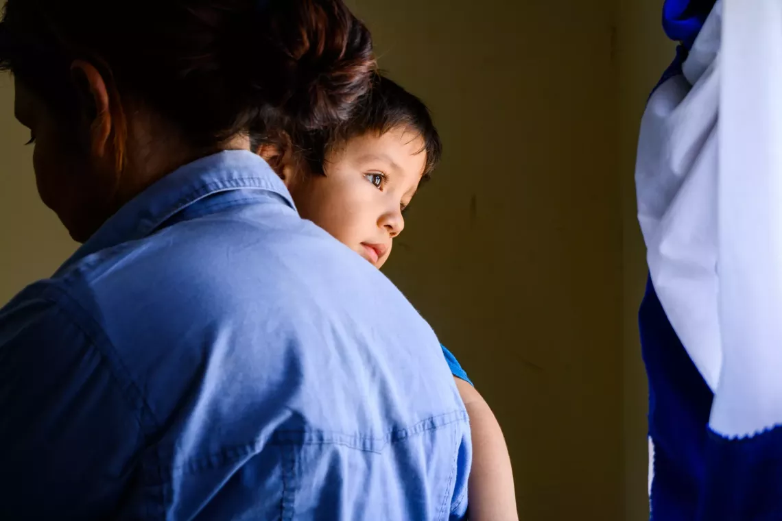 Un nene en brazos de su mamá espera a ser atendido por la médica local