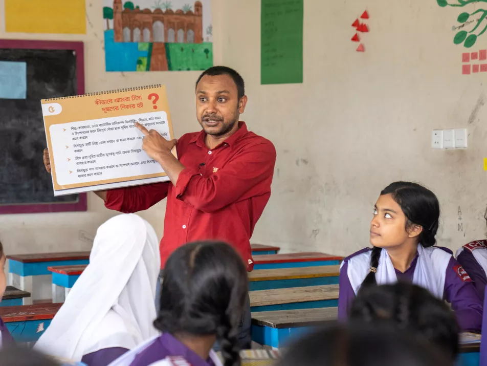 Teachers raise awareness among school students with the help of social and behavioural change materials like handbooks in a health education session on increasing lead poisoning prevention on 18 November 2023.