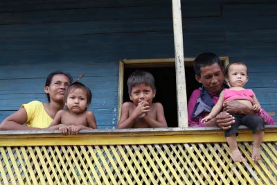 uma família indígena posa para foto em sua palafita na Amazônia