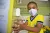 Foto mostra um menino de máscara e uniforme escolar lavando as mãos.