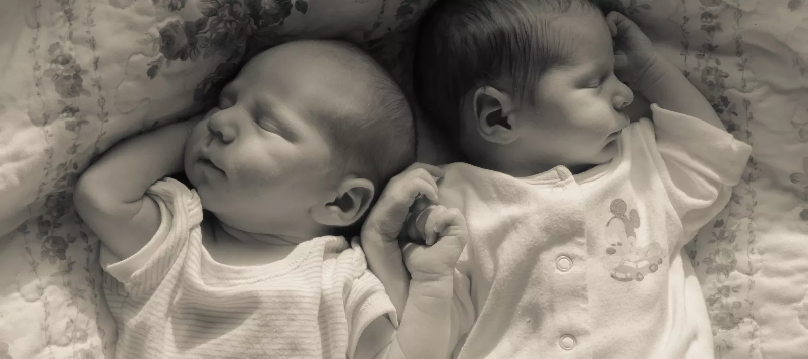Две бебета спят сладко хванати за ръце