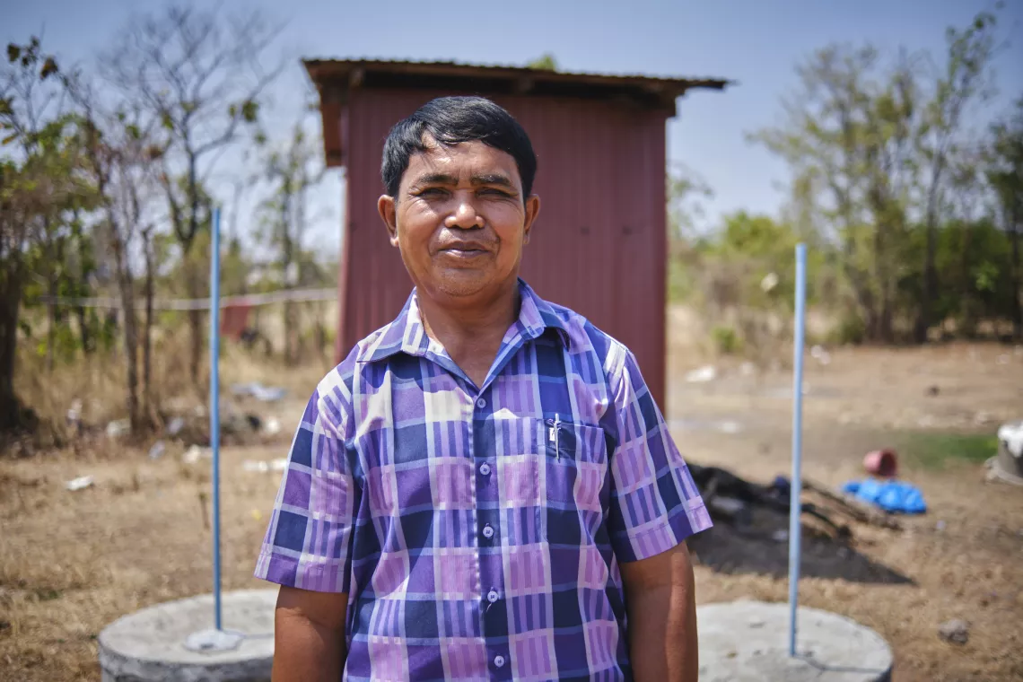 Koloab village chief Ey Channak has spent time and energy supporting households to build alternating twin pits (pictured behind) at their home, helping his village become open defecation free 