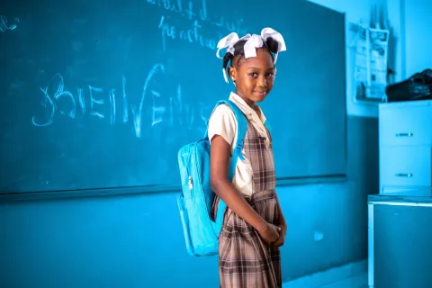  A student poses with a UNICEF backpack during a Back to School Ceremony
