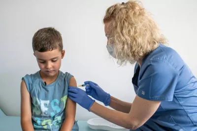 In Krakow, Poland, 6-year-old receives his immunizations from Nurse