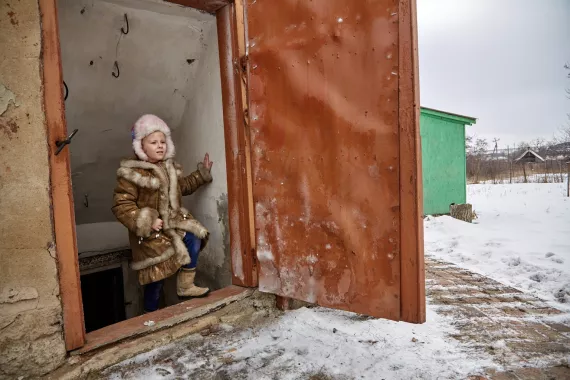 Sasha, 6, steps out of her cellar in eastern Ukraine where her, her sister, and their grandmother shelter when there is shelling.