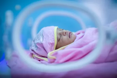 A pre-term baby is kept warm in an incubator