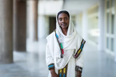 A young girl wearing Ethiopian traditional clothes, and posing for the camera 