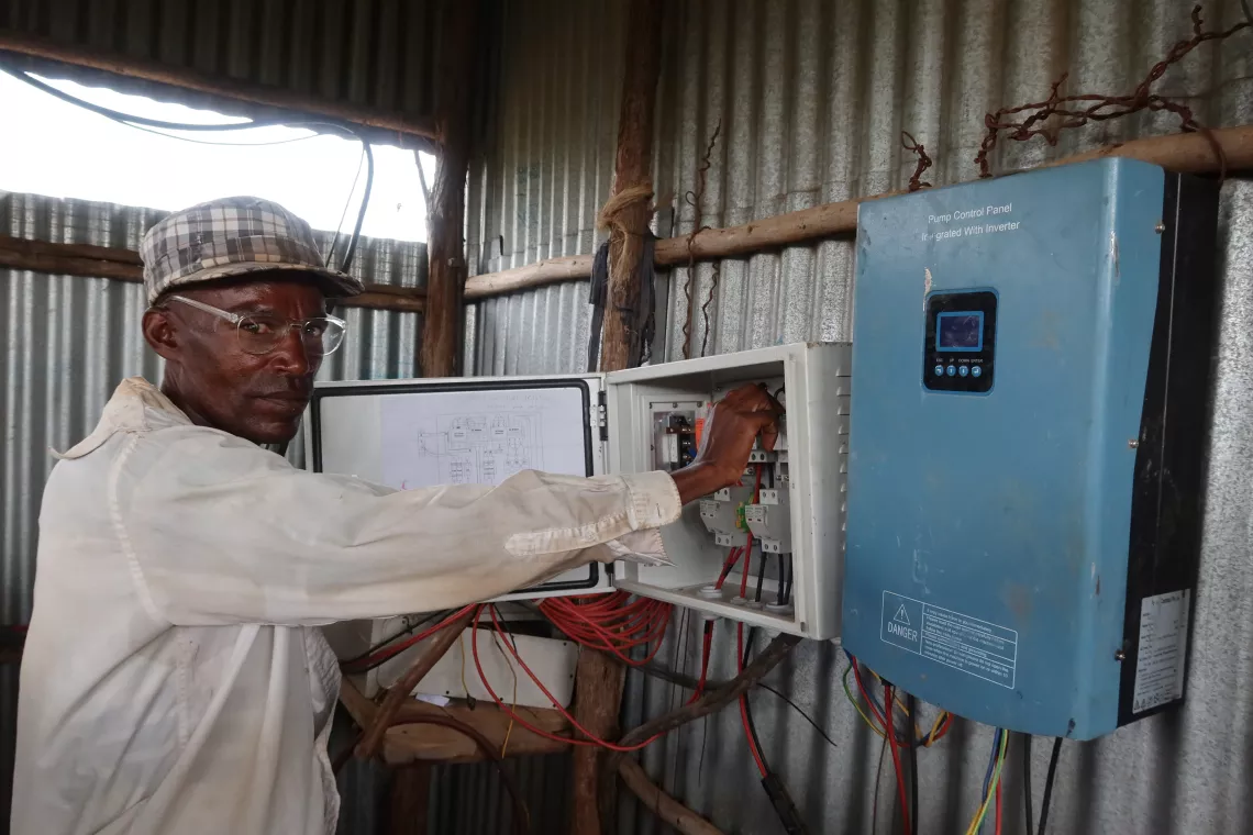 A young man operating on a solar powered water system