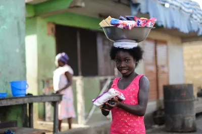 A girl selling soaps and washing powder out of a basin carried on her head in the historic slaving town of Elmina in the Central Region of Ghana on 20 May 2012.