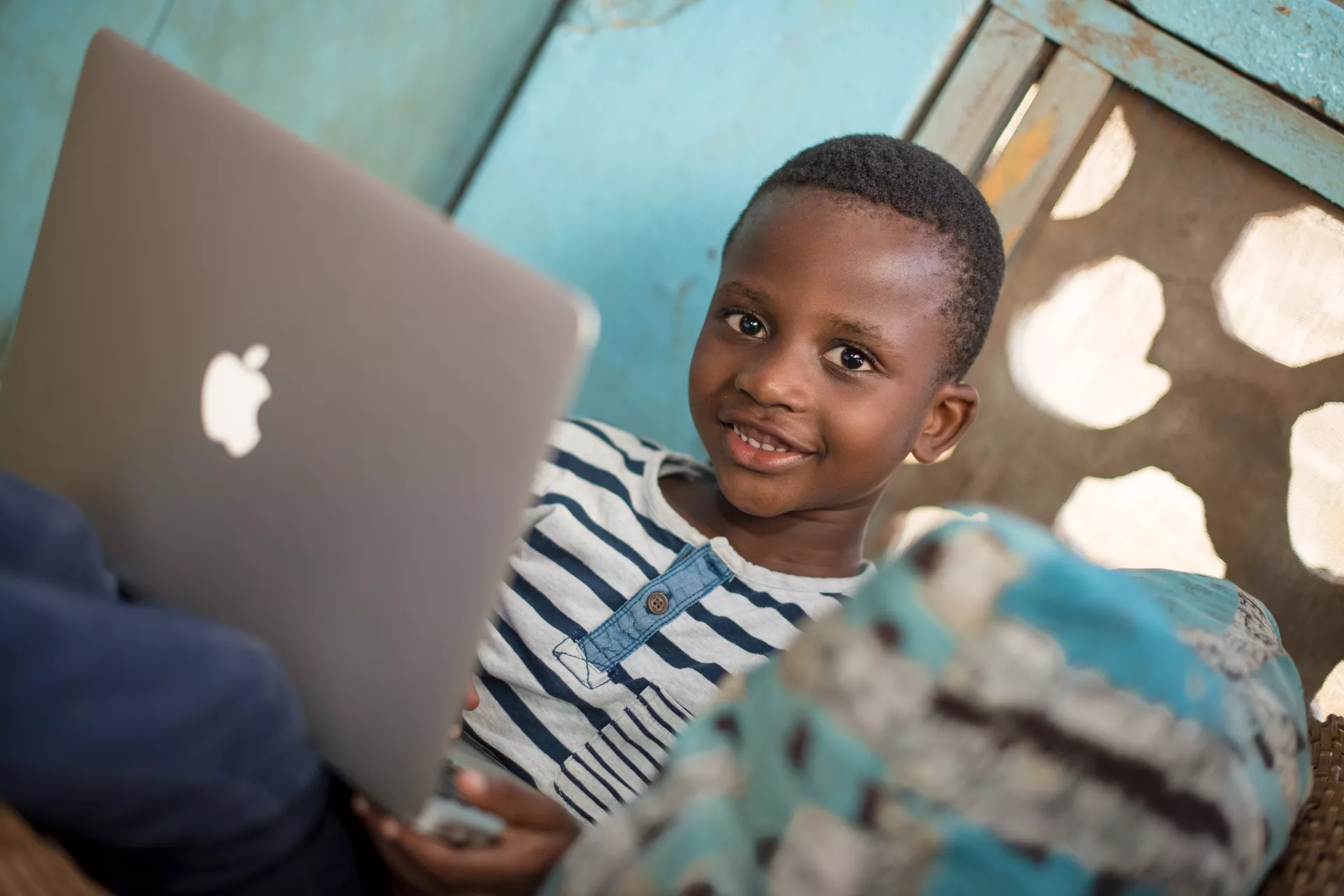 A young boy plays on his mother computer.