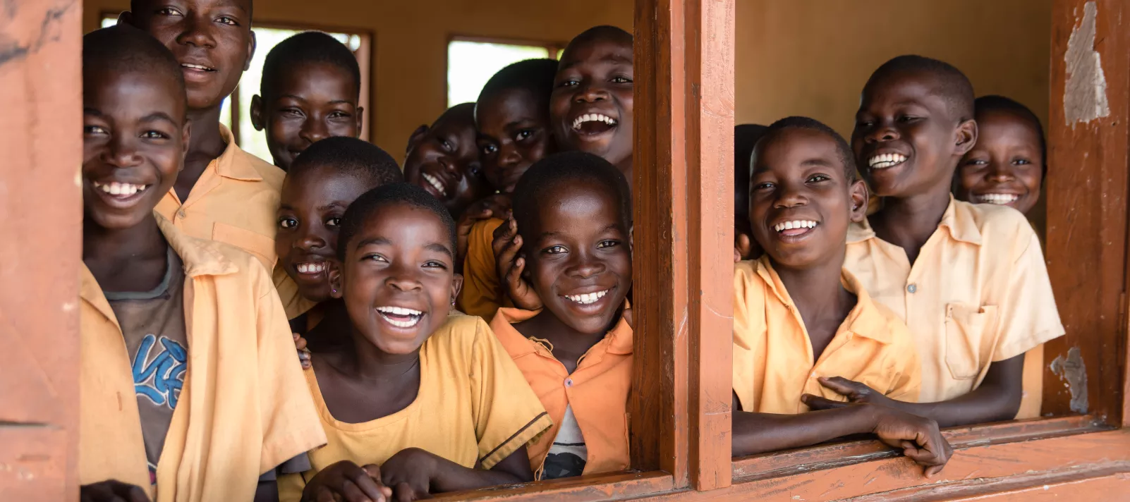 Children smiling from their classroom in Krachi Nchumuru in the Volta Region.