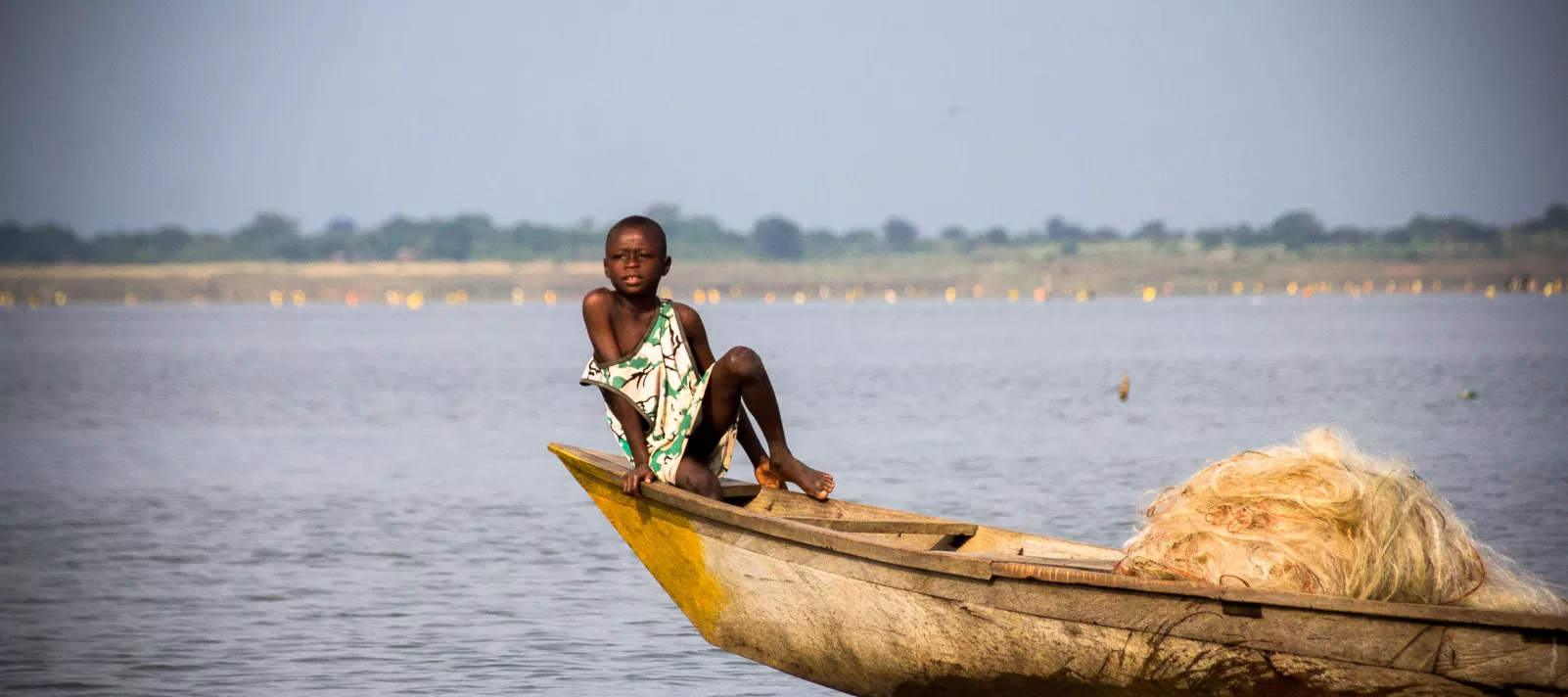 A young boy rest on a canoe on the Volta Lake in Dambai in the Volta Region