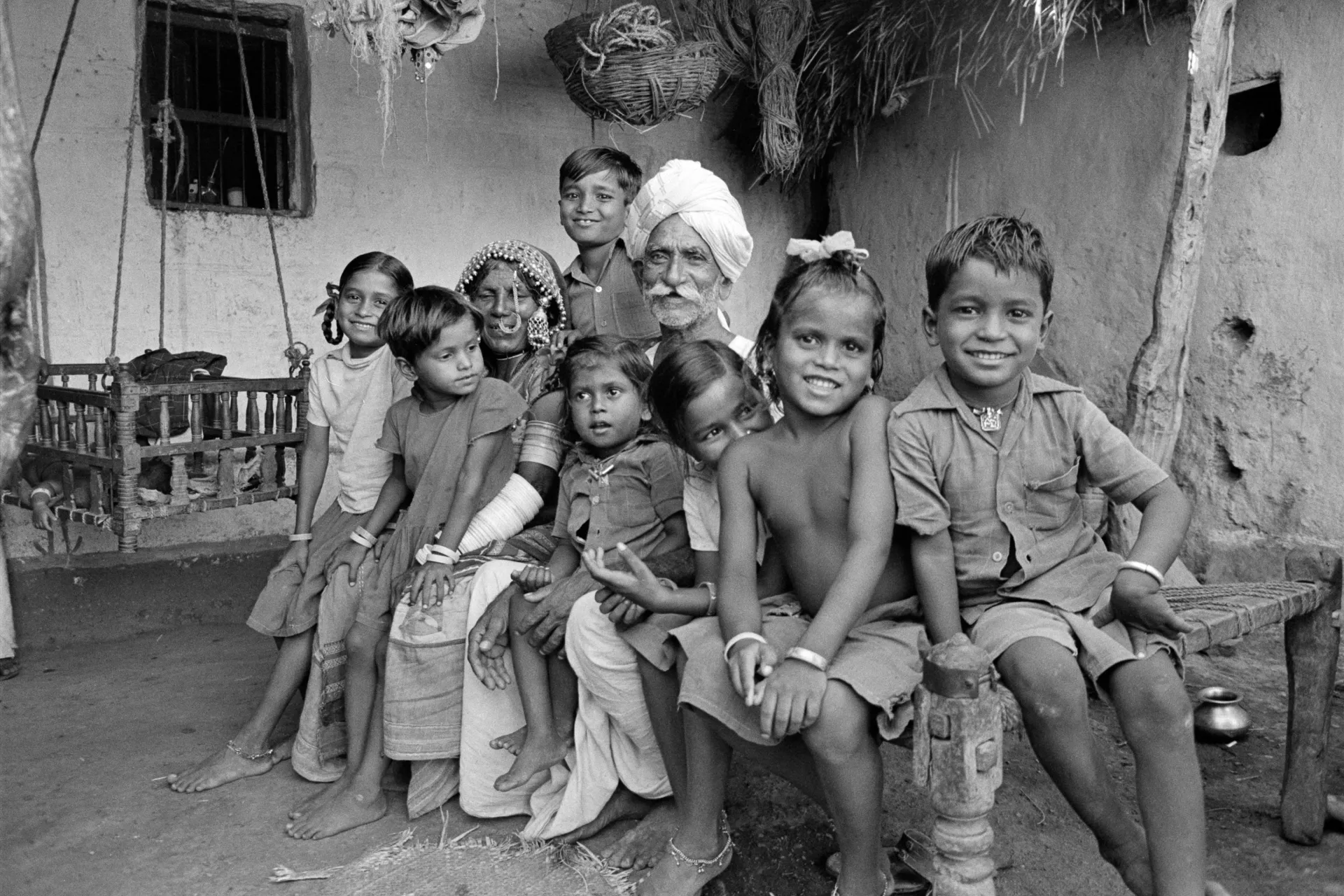 In 1985 in India, an elderly couple from the nomadic Banjari tribe sits smiling with their grandchildren in a dwelling near the south-central city of Hyderabad, capital of the state of Andhra Pradesh.