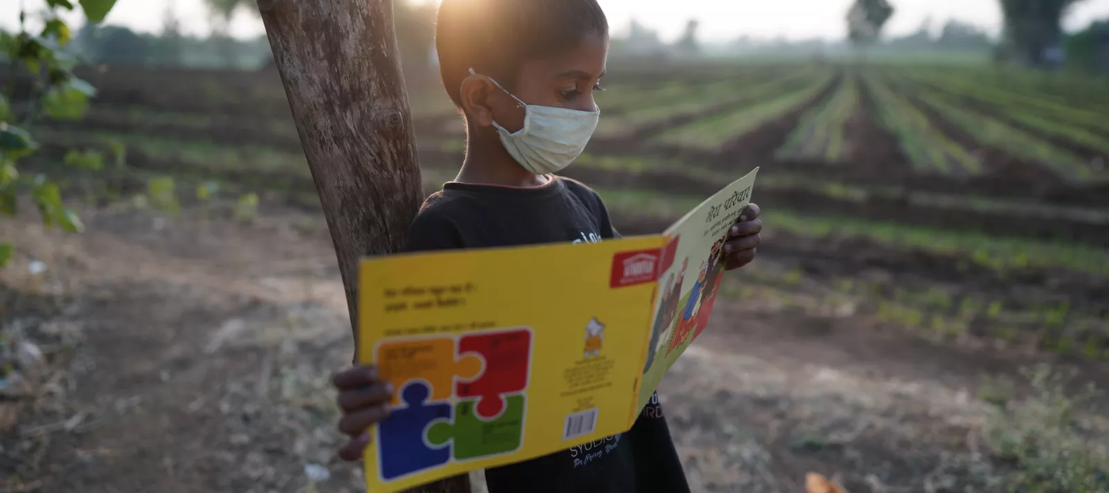 8 year old Akash reads a pratham book outside his house that has been given to him under the library program of Room to Read in Gumdiya Bujurg, Block Niwali, Barwani, Madhya Pradesh.