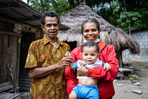 Marten Soleh, Yuliana Nenotek, dan putranya, Sami Sole, 8 bulan, di depan rumahnya di Desa Maunum, Nusa Tenggara Timur.