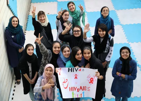 girls holding a banner against HIV/AIDS
