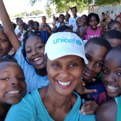 Photograph of UNICEF Jamaica Operations Manager Audrey Tulloch on Play Day 2018 with schoolchildren at a school in Kingston.