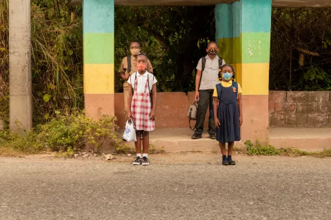 Schoolchildren waiting at a bus stop in Jamaica