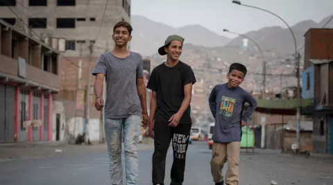 Rubén Rodríguez and his two younger brothers walk down a street in their neighbourhood