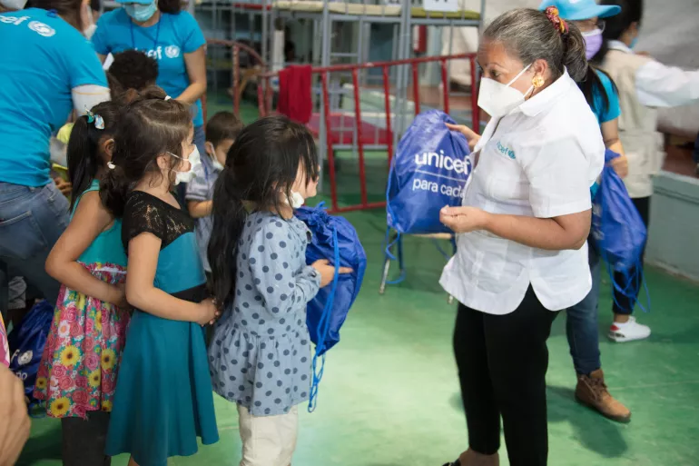 Jean Gough, Directora Regional de UNICEF para América Latina y el Caribe, entrega kits de higiene de UNICEFa unas niñas en el Gimnasio Municipal Kiki Romero en Ciudad Juárez, Chihuahua, México, el 12 de abril de 2021. 