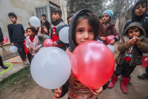 A child carrying two balloons