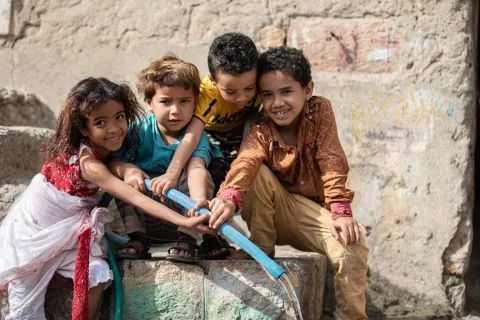 Children while filling a pail with water in Al Nusayria Neighborhood - Al Mudhaffar District - Taizz Governorate, and they are extremely happy with the water arrival.