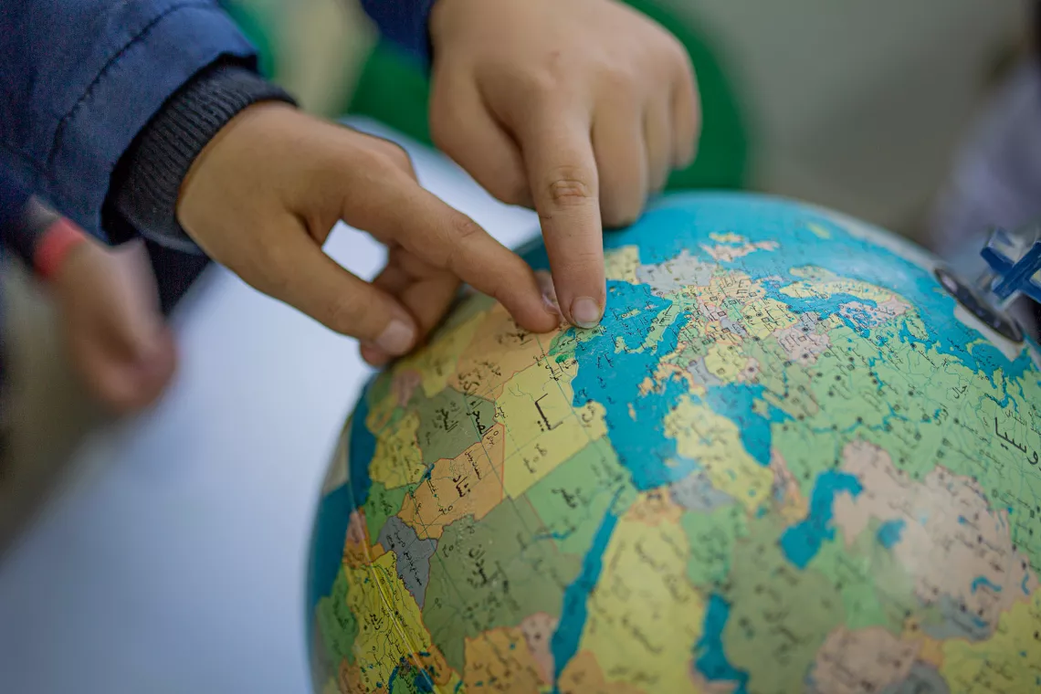 Children point out Tunisia on a globe. 