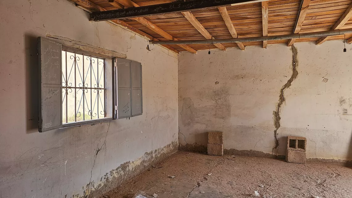 An old classroom at Taqrouteen School, with its stark walls bearing cracks and a bare wooden ceiling, stands empty, a reminder of the school's need for restoration. Photo: ©UNICEF/Wadi Otbah/2023/Abdullah Hussein
