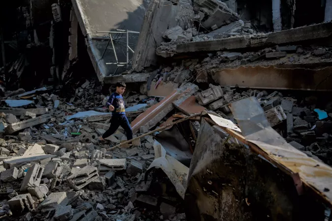 A 9-year-old child walks over the rubble of his destroyed home at Omar Al-Mukhtar Street in Gaza City.