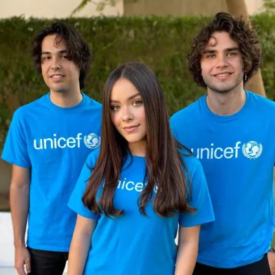 Angie, Abe y Gus portando la playera de UNICEF