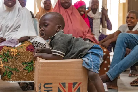 Adamu Abubakar, an 18-month-old boy, joyfully played on a carton of hygiene kits
