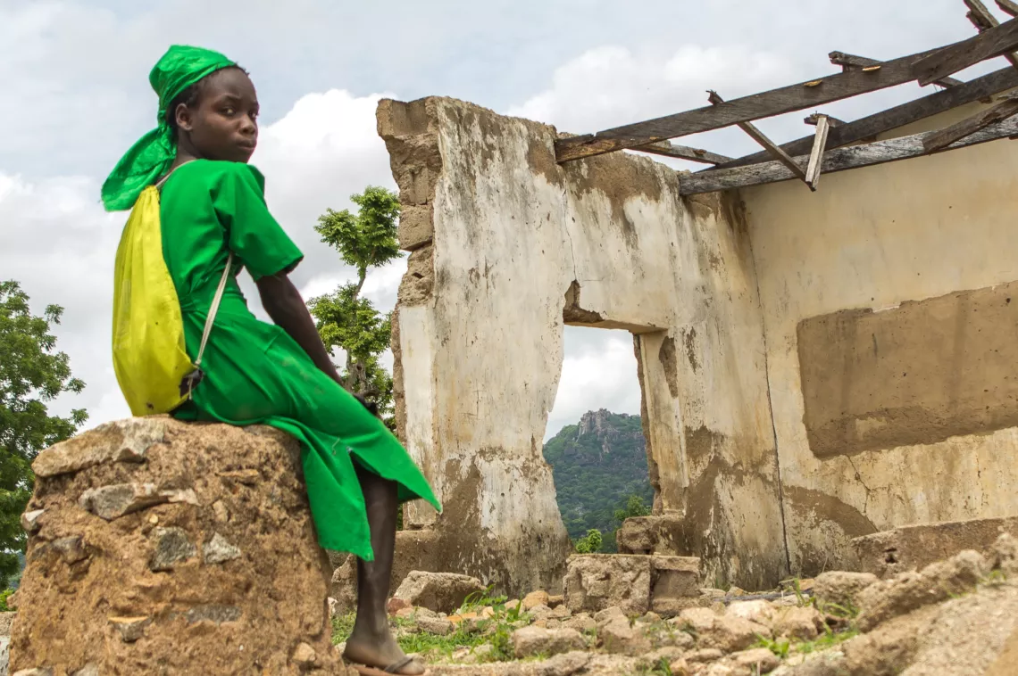 A schoolgirl sits outside her classroom destroyed by insurgents in northeast Nigeria