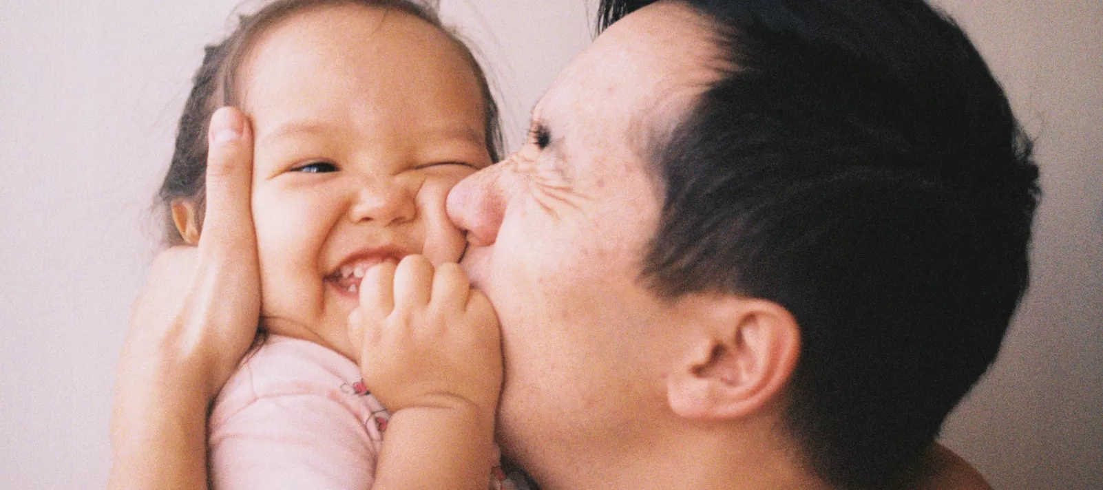 Un père embrasse sa petite fille sur la joue
