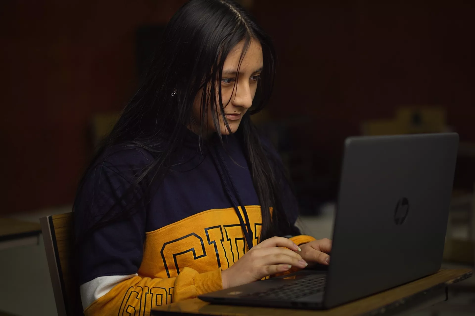 Una adolescente mujer usa una laptop
