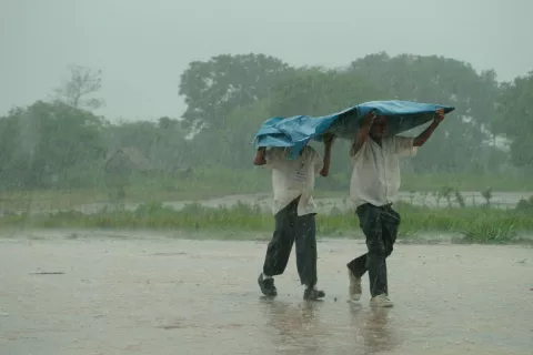 Ninos caminando bajo intensa lluvia