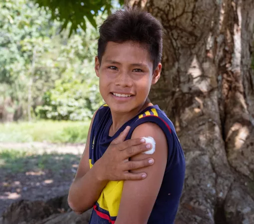 Un adolescente sostiene un algodón en su brazo luego de ser vacunado