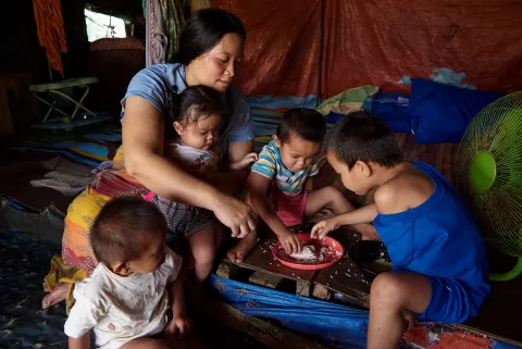 Ayesha Pondogar feeds her children in Kadinglan Evacuation Centre