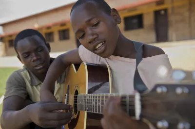 Two young boys in Rwanda play guitar