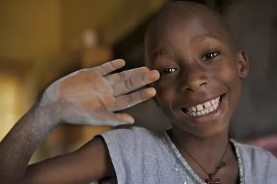 Girl in Rwanda waves at camera