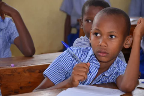 A child in a classroom attentively following a class session