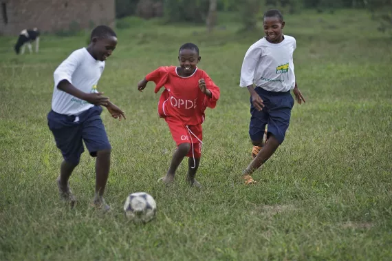 Children at a UNICEF-supported centre for street children play football together in Rwanda.
