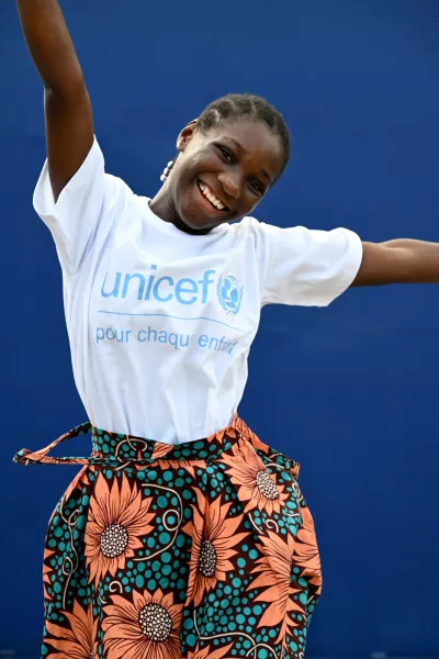 young girl jumping and smiling with a UNICEF T-shirt