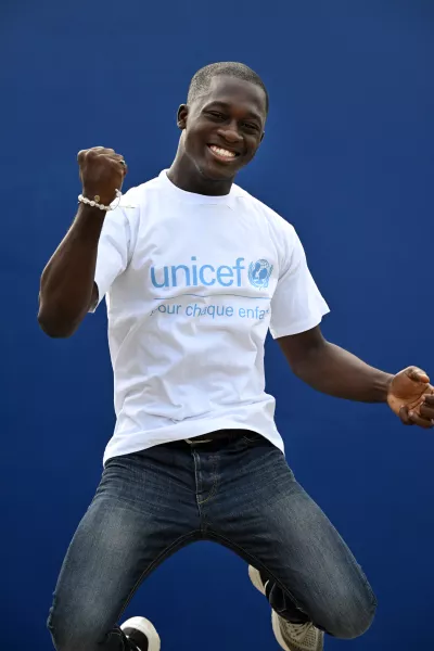 young boy jumping with a UNICEF t-shirt.