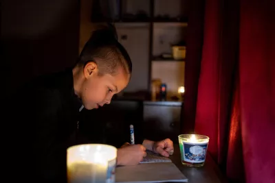 Ukraine. A boy does his homework by candlelight in Bucha, Ukraine.