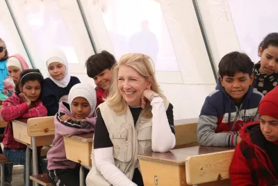 La directora ejecutiva de UNICEF, Catherine Russell, sentada con niños durante su visita a la escuela Ahmad Adeeb Al-Ali